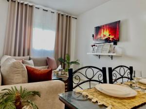 a living room with a couch and a table with a fireplace at S&H Home Martil Apartment in Martil
