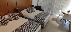 a hotel room with two beds and a table and a dining room at Búzios Beach Resort Residencial 1322 in Búzios +32 photos
