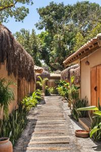a walkway between two houses with trees at Villa Rio Caraiva in Caraíva