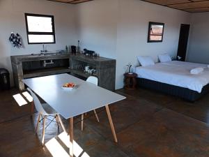 a bedroom with a bed and a table and a table and chairs at Alt Duwisib Nature Escape in Duwisib +17 photos