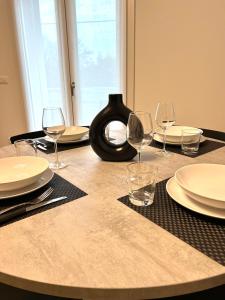 a table with plates and wine glasses on it at Appartamento a Quarto D Altino - La Rosa del Sile in Quarto dʼAltino