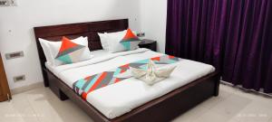 una camera da letto con un grande letto con cuscini colorati di Kapsstone SERVICED APARTMENT- ROOMS near Ashok pillar a Chennai
