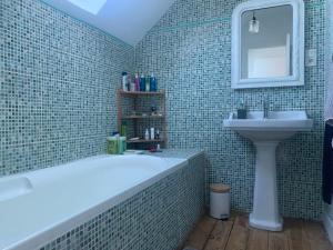 ein Badezimmer mit Badewanne und Waschbecken in der Unterkunft Maison cosy in Larmor-Baden + 24 Fotos