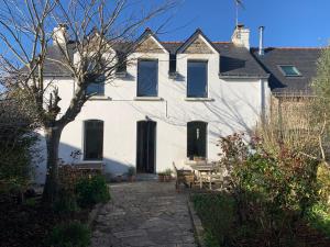 ein weißes Haus mit einem Tisch davor in der Unterkunft Maison cosy in Larmor-Baden