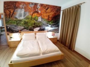 a bedroom with a bed with a painting on the wall at la fonte in Sporminore