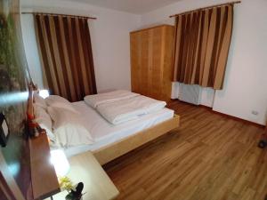 a small bedroom with a bed and a wooden floor at la fonte in Sporminore