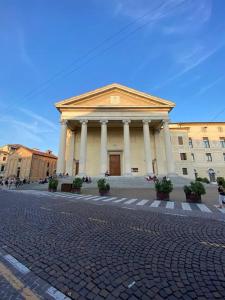 a large building with columns on a street at Alla Torre - Room & Private Bathroom in Treviso +17 photos