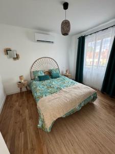 a bedroom with a bed with blue pillows on it at Appartement haute gamme in Lamotte-Beuvron