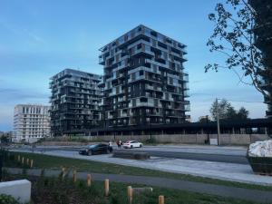 duży budynek z samochodami zaparkowanymi na parkingu w obiekcie Apartament Pierwsza Dzielnica w mieście Katowice