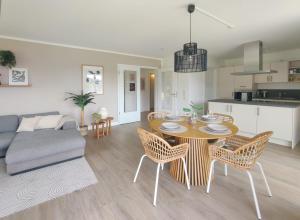 a kitchen and a living room with a table and chairs at INIKAMA - Elegantes Apartment in Rosengarten