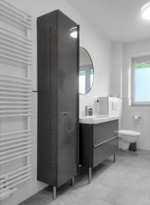 a bathroom with a sink and a toilet and a mirror at INIKAMA - Elegantes Apartment in Rosengarten