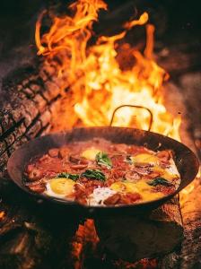 a pan of pizza in front of a fire at Desert Heart in Bidiyah