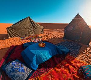 メルズーガにあるDesert Backpackers Campの砂漠の中のテントとテーブル