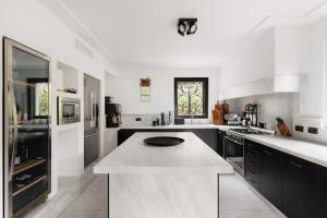 a large white kitchen with a large island in it at Villa MUSA in Lenno