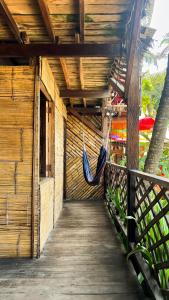 a porch with a hammock hanging from a building at Hostal halaliku tayrona in Santa Marta