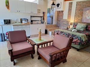 a kitchen with two chairs and a table and a bed at Tehillah Guesthouse in Klein-Brakrivier
