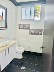 y baño con aseo, lavabo y ventanas. en Lujosa casa cerca al aeropuerto, en Medellín 18 fotos más