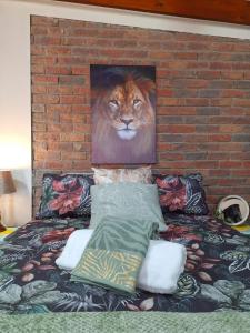 a painting of a lion on a wall next to a bed at Tehillah Guesthouse in Klein-Brakrivier +16 photos