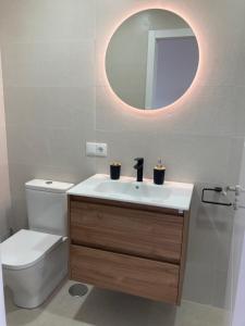 a bathroom with a toilet and a sink with a mirror at Playa Alcabre in Vigo +12 photos