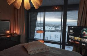 a bedroom with a large window and a television at Gennachblick 1 Ferienhaus im Allgäu in Bidingen