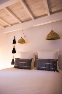 MartrinにあるLa maison Charlélieの白いベッドと枕が2つある寝室