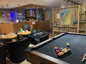 a pool table in a restaurant with tables and chairs at Hôtel Des Argousiers in Ambleteuse