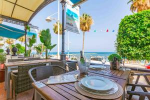 una mesa de madera con platos y vistas a la playa en Hotel Altaia, en Altea