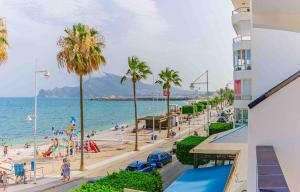 vistas a una playa con palmeras y gente en Hotel Altaia, en Altea