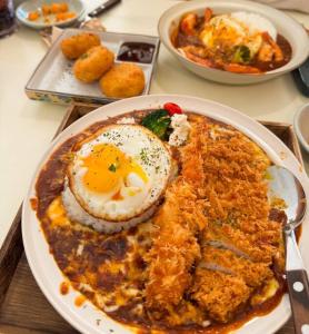 a plate of food with an egg on a table at Casa Choi 3 Bedroom Apartment in Seoul in Seoul