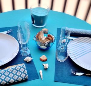 a table with plates and glasses and a bowl of ice cream at L'escale du capitaine in Leucate