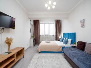 a hotel room with a bed and a couch at Appartments " Zhetysu-4" in Almaty