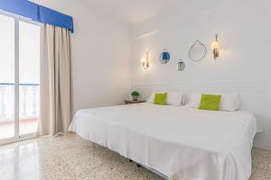 1 dormitorio blanco con 1 cama blanca grande con almohadas verdes en Hotel Altaia, en Altea