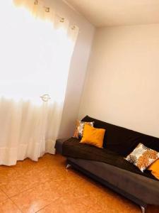 a black couch in a room with a window at Maravilhosa casa no centro de Foz do Iguacu in Foz do Iguaçu