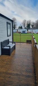 a wooden deck with a bench on top of a house at Ramblers Retreat in Cockermouth