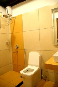 a bathroom with a toilet and a sink at Poovar Heritage Homes in Pūvār