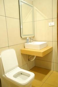 a bathroom with a white toilet and a sink at Poovar Heritage Homes in Pūvār +2 photos