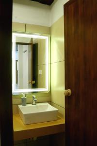 a bathroom with a sink and a mirror at Poovar Heritage Homes in Pūvār