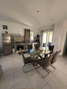 a kitchen with a glass dining table and chairs at Maison La Surprise in Saint-Leu