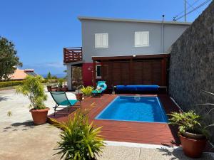 a backyard with a swimming pool and a house at Maison La Surprise in Saint-Leu
