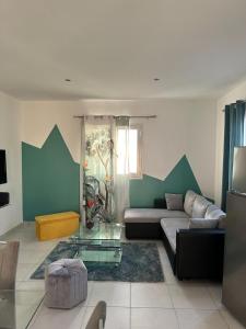 a living room with a couch and a table at Maison La Surprise in Saint-Leu