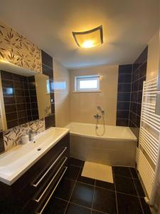 a bathroom with a white tub and a sink at Apartmán Hollého in Žilina