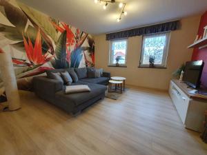 a living room with a couch and a tv at Ferienwohnung-Thale-Ritter in Thale