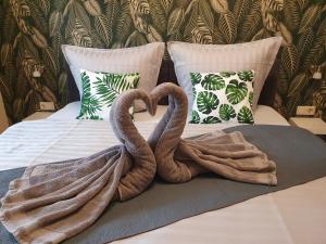 two towel swans sitting on top of a bed at Ferienwohnung-Thale-Ritter in Thale