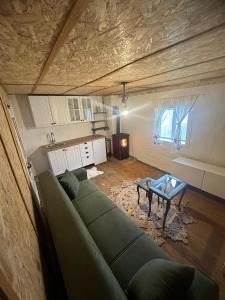 a living room with a green couch and a table at Vikend kuce i odmaraliste JuliE etno - Sarajevo Jahorina in Tvrdimići