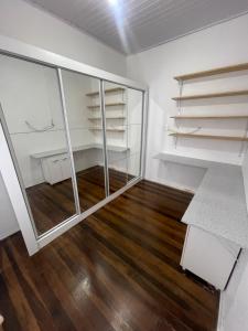 an empty room with glass shelves and wooden floors at Lindo quarto Quadra Mar in Barra Velha
