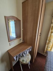 a room with a wooden dressing table and a mirror at 8 Berth Caravan - North Shore Holiday Park Skegness 3 Bedrooms in Skegness +6 photos