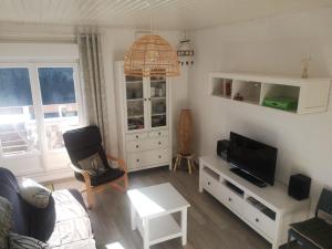 a living room with a couch and a tv at La Bresse OURSON in La Bresse