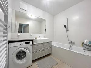 bagno bianco con lavatrice e lavandino di Wohnung mit Garten in 1230 Wien a Vienna