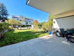 un patio con sedie e un cortile con un edificio di Wohnung mit Garten in 1230 Wien a Vienna