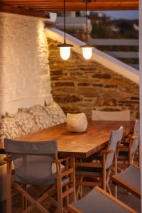 a wooden table and chairs in a room at Para Principe Tinos in Agios Sostis